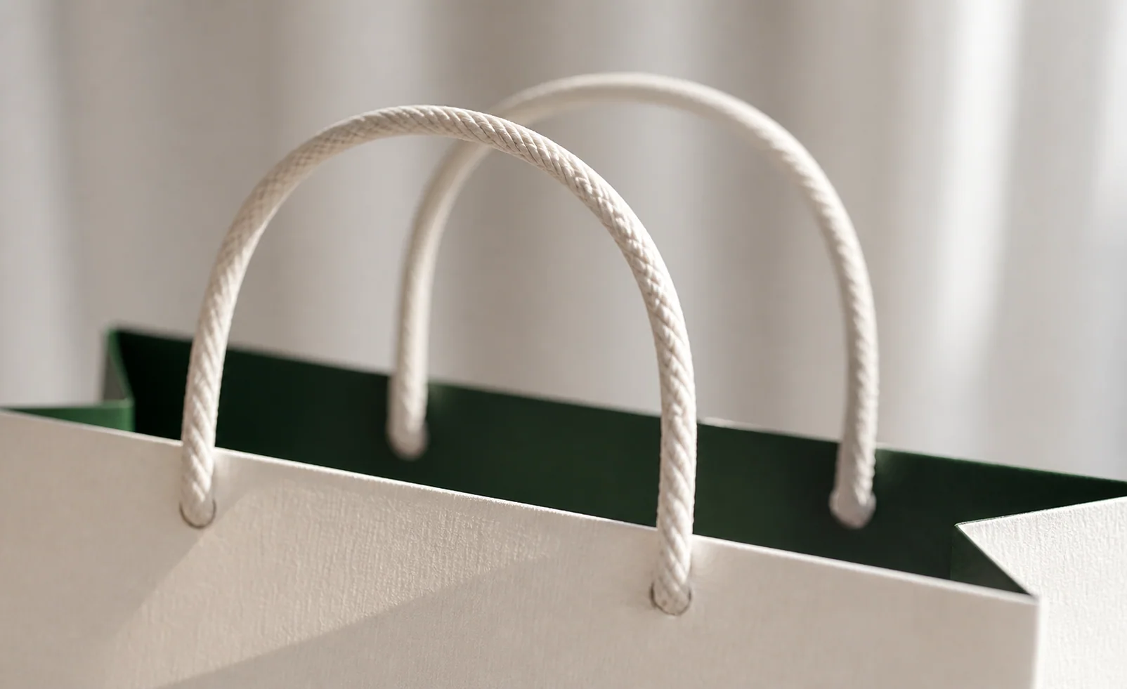 Close-up of soft paper-fiber handles on a premium shopping bag